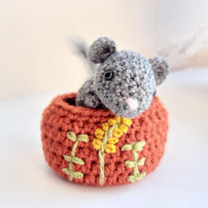 Grey mouse ornament crochet art figure on top of embroidered nest