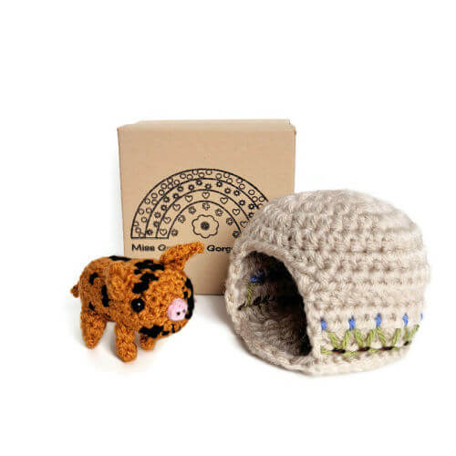 A cute little spotted piglet crochet art figure with embroidered sty and gift box