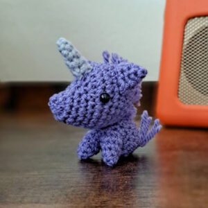 Purple crochet unicorn ornament on bedside table