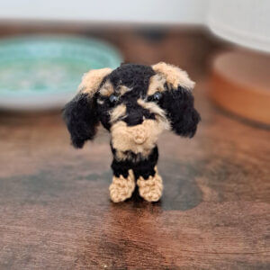 A wire-haired dachshund gift crochet figure in black and tan.