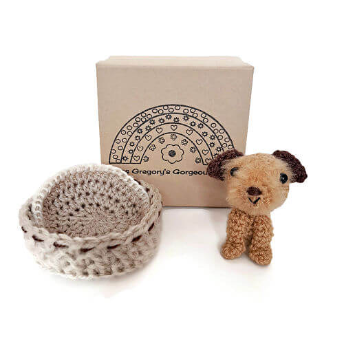 a brown border terrier gift crochet art figure with a little bed basket, blanket and gift box