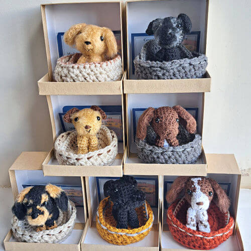 A set of 7 dog figurines each in a little cosy basket and gift box