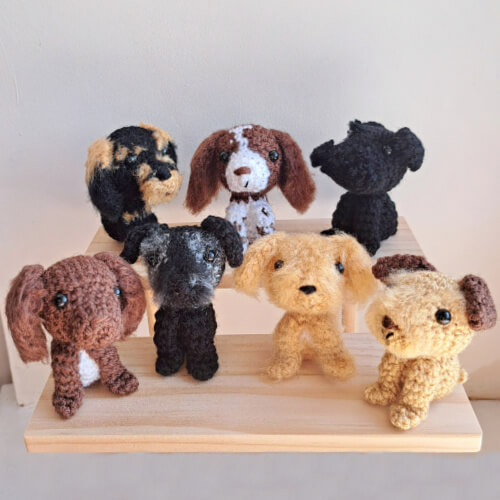 A set of 7 dog figurines sitting on a shelf