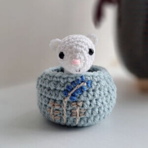A cute little ermine ornament sitting in an embroidered nest Miniature Animal Figurine Ermine / Winter Stoat