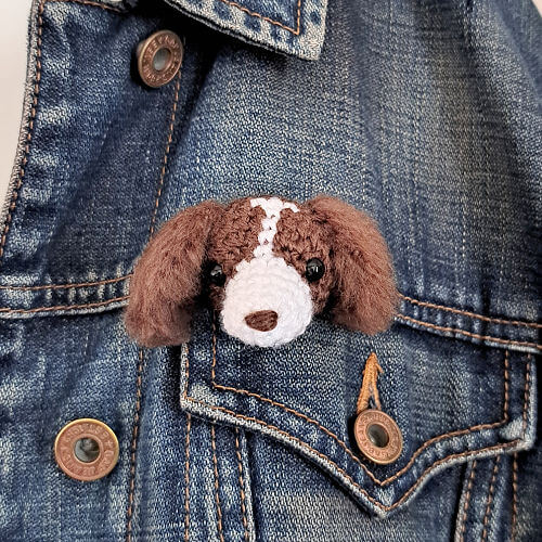 A springer spaniel crochet art brooch styled on a denim jacket